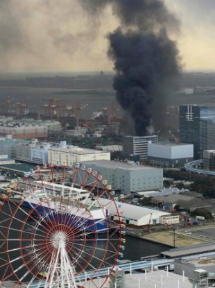 Black smoke rises from a burning building in Tokyo after Japan was struck by a magnitude 8.9 earthquake off its northeastern coast Friday, March 11, 2011.