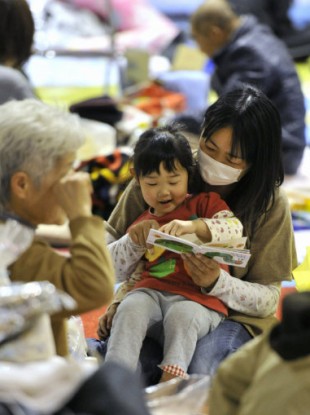 A mother and her daughter read a picture book in a shelter in Iwaki, Fukushima Prefecture, on March 14, 2011.