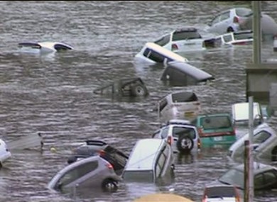 In this image made off Japan's NHK TV video footage, vehicles are washed away by tsunami in coastal area in eastern Japan after Japan was struck by a magnitude 8.9 earthquake off its northeastern coast Friday, March 11, 2011.
