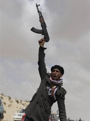 A Libyan rebel shouts religious slogans before heading towards the frontline, near Brega, Libya, Saturday, April 2, 2011.