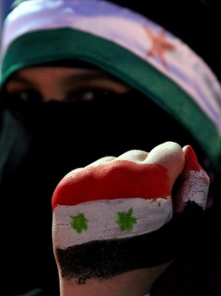 A Syrian protester holds up her hand, painted with the colors of the national flag at a demonstration demanding that Syria's President Bashar Assad step down.