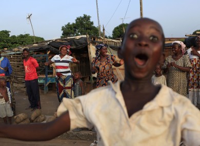Street vendors and children celebrate the impending inauguration of President Alassane Ouattara