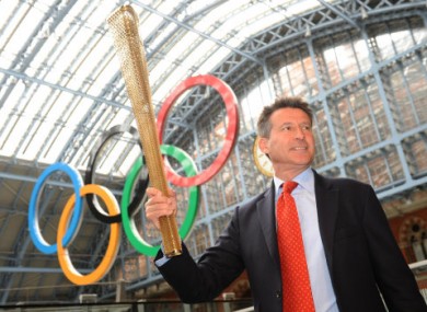 Sebastian Coe holds the newly-designed Olympic torch aloft.