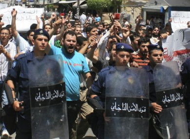 Lebanese riots police officers march in front of anti-Syrian president Bashar Assad protesters, during a demonstration against the Syrian regime, in Tripoli, northern Lebanon, on Friday June 10, 2011.