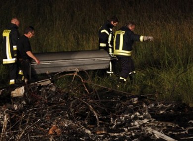 Rescuers carry a coffin at the airfield in Reichelsheim, central Germany, early Monday June 13, 2011.