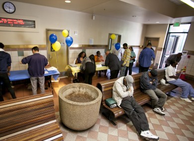 Job seekers register for a career fair as homeless men sleep on benches in downtown Los Angeles
