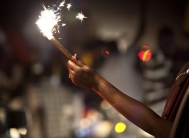 A woman holds a sparkler out of a car window in celebration of South Sudan's impending independence in Juba, South Sudan, late Friday, July 8, 2011.