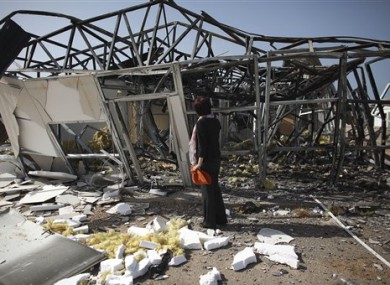 In this photo taken on a government-organized tour, a journalist inspects a building that Libyan officials say was destroyed in an airstrike, near the town of Zlitan.