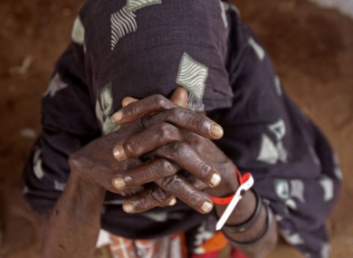 An elderly woman waits inside a food distribution center after being registered as a refugee in Dadaab, Kenya, Monday, 1 Aug, 2011.