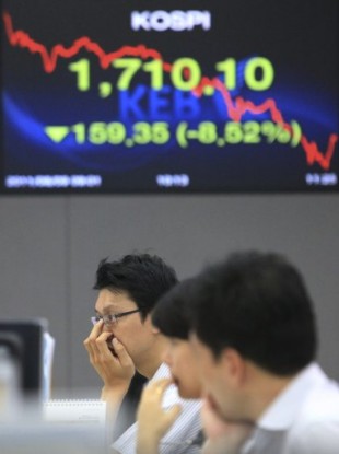Currency traders work in Seoul, South Korea, Tuesday, Aug. 9, 2011.