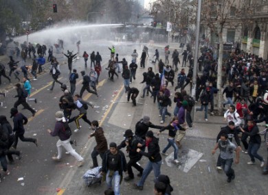 Police fire water cannons on demonstrators trying to reach La Moneda presidential palace during a march on the second day of a national strike in Santiago, Chile.