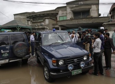 Pakistani media follow a senior police officer at outside the house of a abducted American citizen in Lahore, Pakistan on Saturday, Aug. 13, 2011.