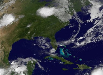 This image provided by NASA taken at 2:32 a.m. EDT Wednesday morning Aug. 3, 2011 shows tropical storm Emily, lower right.
