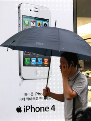 A man passes by an Apple iPhone advertisement at downtown Seoul, South Korea, Tuesday, Aug. 17, 2011.