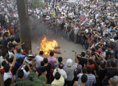 Anti-Syrian regime protesters of Islamic group suppoters burn an effigy of Syrian President Bashar Assad Tripoli, Lebanon, on Friday Oct. 7, 2011.