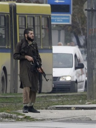 An gunman, identified as Mevlid Jasarevic, stands with an automatic weapon in the centre of the street in front of the US embassy in Sarajevo, Bosnia, Friday, Oct. 28, 2011.