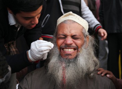 An injured man receives treatment during today's clashes at Tahrir Square.