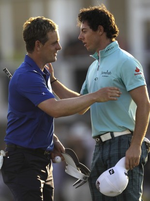Luke Donald, left, and Rory McIlroy shake hands after they finished the first round of Dubai World Championship earlier.