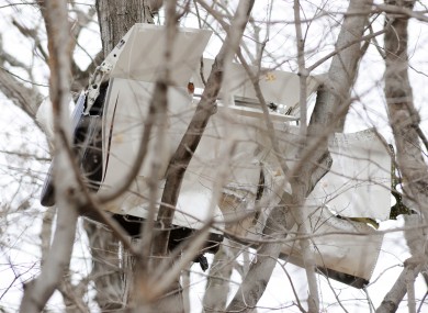 A piece of the plane hangs from a tree near the scene of the crash