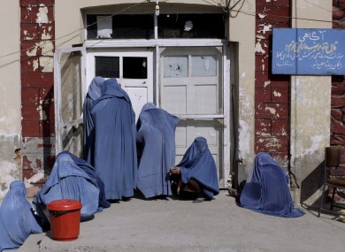 File photo: Afghan women peek inside a hospital while she and others wait for an employee to let them enter, on the outskirts of Kabul, Afghanistan