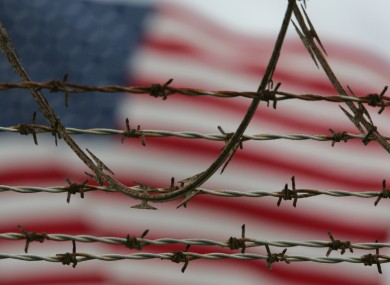 A flag waves behind the barbed and razor-wire at the detention compound on Guantanamo Bay US Naval Base in Cuba