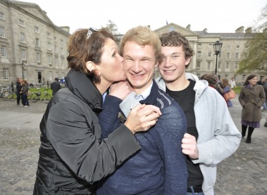 Myles McCormack from Rathmines, one of Trinity College's new scholars, is congratulated by his mother Philippa and brother Conor in the front square of Trinity College today.