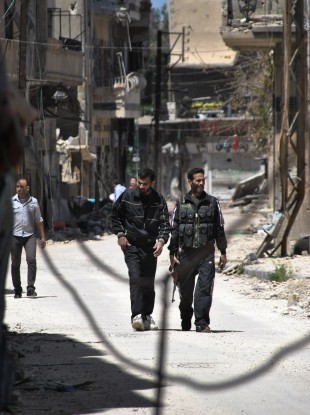 Free Syrian Army fighters walk on street in Khaldiyeh neighborhood in Homs, Syria
