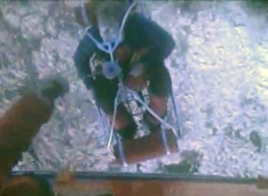 This framegrab image provided by the U.S. Coast Guard shows one of three crew members from the yacht Low Speed Chase being rescued