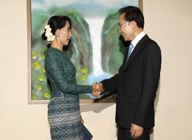 South Korean President Lee Myung-bak, right, shakes hands with Burma's opposition leader Aung San Suu Kyi