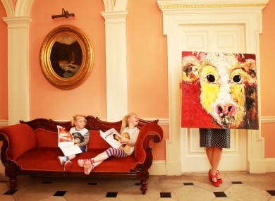 Irish artist Deborah Donnelly holds one of her paintings while watched by her children during the launch of a new series of books aimed at painting enthusiasts.