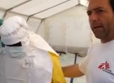 Gray demonstrates what protective clothing MSF staff wear