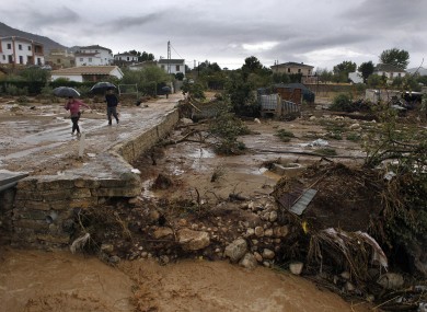 Residents walk on a muddy street after heavy rain caused flash floods in the town of Villanueva del Rosario, Malaga, southern Spain.