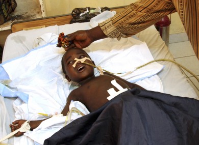 An 11-year-old boy, accompanied by his father, receives treatment at the HEAL Africa hospital after being shot in the abdomen during a firefight between Congolese police and attacking M23 rebels.