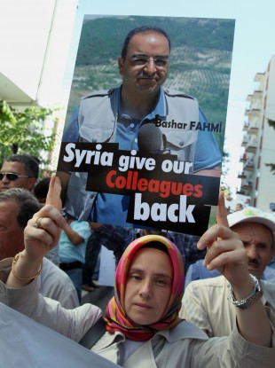 Arzu Kadumi, wife of journalist Bashar Fahmi, captured by Syrian forces, joins some 200 Turkish journalists marching to the Syrian embassy in Ankara, Turkey, Friday, Aug. 31, 2012