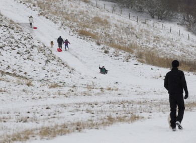 Children play in the snow in Cheshire, England. Four people were killed in an avalanche in Scotland yesterday.