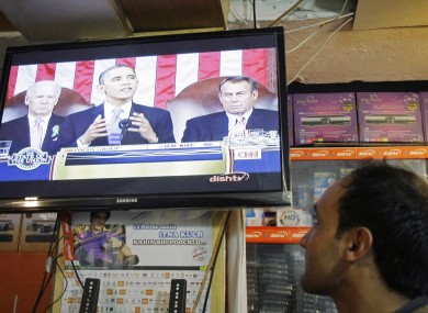 An Afghan man listens to a television news report on U.S. President Barack Obama's State of the Union in Kabul