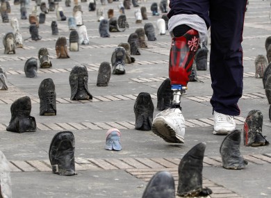 A Colombian amputee soldier, victim of a landmine, walks through a shoe installation marking International Day for Landmine Awareness in Bogota on 4 April, 2011.