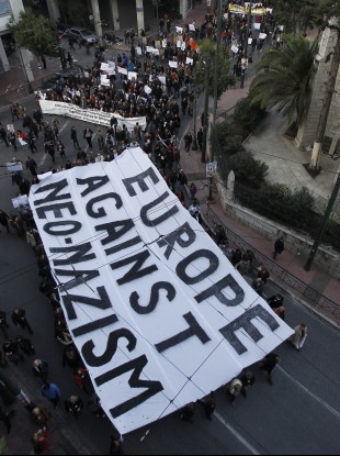 Protesters hold a giant banner during a silent march through the streets of Athens in protest against racism and neo-nazism.