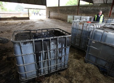 A customs officer looks at containers of sludge at a fuel laundering plant unearthed in Knightstown, Co Meath, following a raid by Customs and Garda officers in 2011.