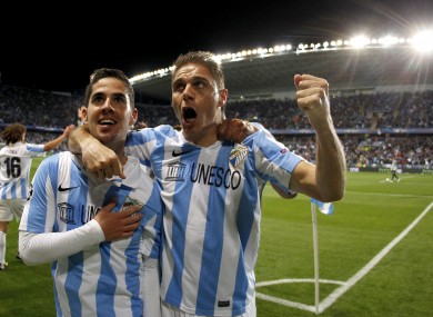 Malaga's Isco Alarcon from Spain, left, celebrates with teammate Joaquin Sanchez after scoring against FC Porto during the Champions League round of 16 second leg match.