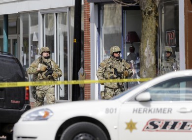 Law enforcement officers walk along Main Street in Herkimer, N.Y., while searching for a suspect in two shootings that killed four and injured at least two on, Wednesday, March 13, 2013.