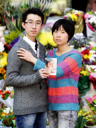 Meijiao Yu and her husband Xiao Shao hold a picture of their daughter Jiayi.