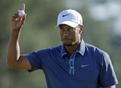 Tiger Woods holds up his ball after putting out on the 18th hole during the third round of the Masters golf tournament.