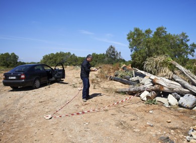 A plain clothed police officer investigates an area where a 12-year-old Russian boy was found wounded in the holiday resort of Hersonissos, on the Greek island of Crete.