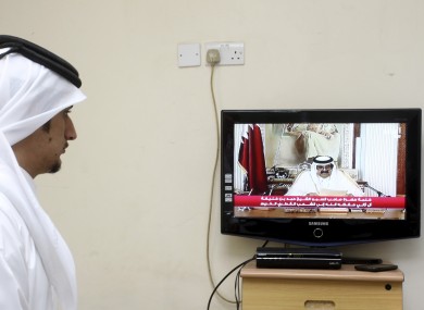 A man watches a televised address by Qatar's Emir Sheik Hamad bin Khalifa Al Thani, in Doha today