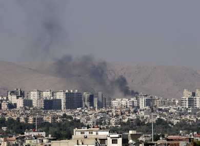 Black columns of smoke from heavy shelling in a Damascus suburb