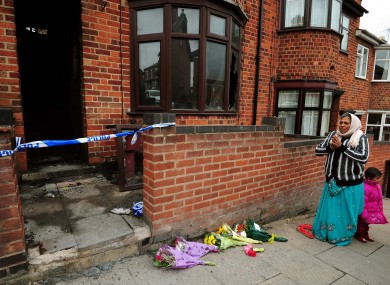 A local resident says a prayer outside the scene of the fatal house fire in Wood Hill, Leicester.