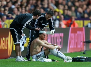 Swansea striker Michu receives attention after picking up a head injury.