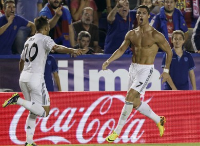 Real Madrid's Cristiano Ronaldo, right and topless, is congratulated by teammate Jese Rodriguez.