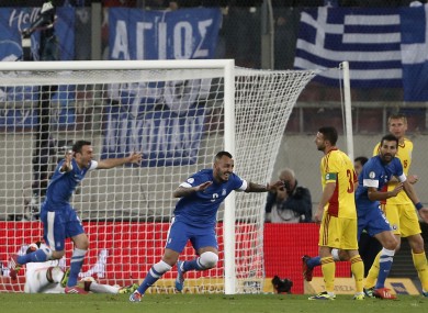 Greece's Kostas Mitroglou, center left, celebrates his second goal against Romania during a World Cup qualifying playoff first leg soccer match at the Karaiskaki stadium in the port of Piraeus.